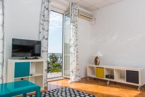 奥帕提亚Sunny Apartment Anamaria Opatija的一间带电视和大窗户的客厅
