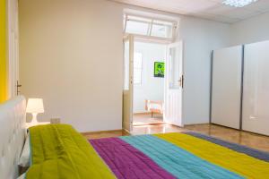 奥帕提亚Sunny Apartment Anamaria Opatija的一间卧室配有一张带彩虹毯子的床