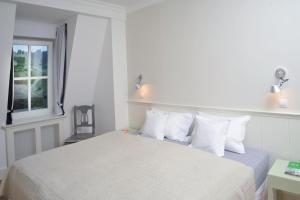玛丽亚温泉Galerie Suites的一间卧室配有一张带白色床单的床和一扇窗户。