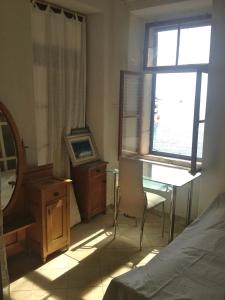 MolatApartments Mediteraneo的一间卧室配有一张床、一张书桌和一个窗户。
