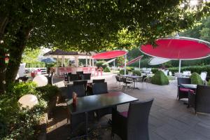 波朗特吕贝乐维尔酒店的一个带桌椅和红色遮阳伞的庭院