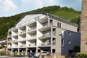 贝尔恩卡斯特尔-库斯Ferienwohnung Edeltrud Deluxe Alte Brauerei Bernkastel-Kues的一座大型公寓楼,前面设有停车场