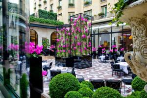 巴黎乔治五世巴黎四季酒店的庭院配有桌椅和粉红色的鲜花