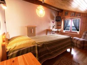 尚波吕克阿尔卑斯弗罗瑞酒店的一间卧室配有一张床、一张沙发和一个窗口