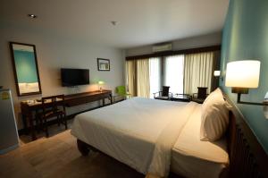 清迈黄创公寓及酒店的配有一张床和一张书桌的酒店客房