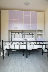 特尔尼Appartamenti Il Cerqueto 2的一间卧室设有两张床和紫色橱柜。