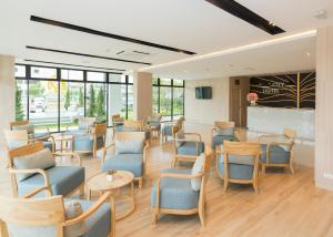 达叻府达勒城市酒店的一间设有蓝色椅子和桌子的等候室