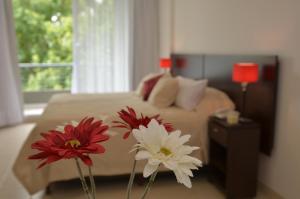 布宜诺斯艾利斯My Apart的一间卧室,配有两朵红色和白色的鲜花