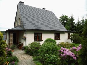 谢勒豪Ferienwohnung Ulbrich的白色的房子,有灰色的屋顶和灌木丛