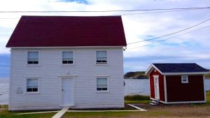 特威林盖特The Old Salt Box Co - Gertie's Place的水体旁有红色屋顶的房子