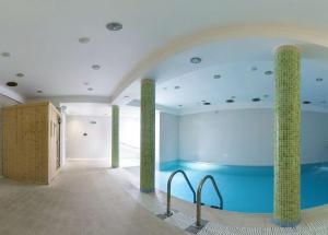 科沃布热格Bursztyn Spa的游泳池位于带两柱的房间里
