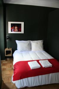 波尔图2U Oporto Urban Stays的一张红色的白色床,上面有两条白色的毛巾