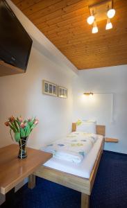 米伦阿尔卑山酒店的一间卧室配有一张带桌子的床和一台电视。