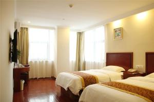 铜陵格林豪泰安徽省铜陵市义安北路财富广场快捷酒店的酒店客房设有两张床和窗户。