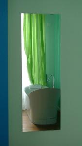 文蒂米利亚菲诺利奥住宿加早餐旅馆的带浴缸和绿色淋浴帘的浴室