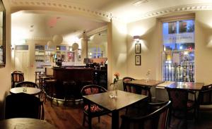 都柏林凤凰公园酒店的一间带桌椅的餐厅和一间酒吧