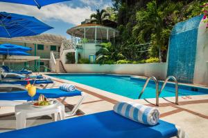 蒙特哥贝德雅全包度假酒店 的度假村的游泳池配有蓝色的桌子和遮阳伞