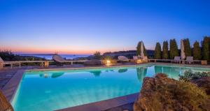 阿吉亚艾里尼帕罗Villas Agia Irini Cove的夜间蓝色海水的大型游泳池