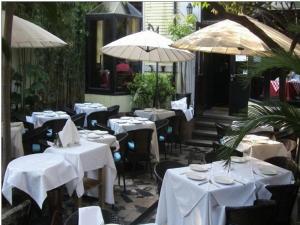 上海凯文之家的一间设有白色桌椅和遮阳伞的餐厅