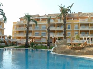 德尼亚Apartamentos Nova Denia - Deniasol的棕榈树酒店前的游泳池