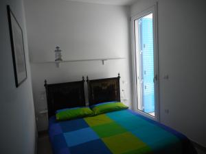 切萨雷奥港Sule Mare Ientu的一间卧室配有一张色彩缤纷的床和窗户