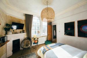 伦敦库尔佩珀酒店的一间卧室配有一张床、一个壁炉和一个吊灯。