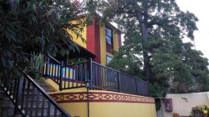圭马尔Hotel Rural La Raya 1866的黄色和红色的建筑,前面有楼梯