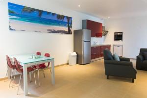 棕榈滩Bubali Luxury Apartments - Adults Only - Wheelchair Friendly的厨房以及带桌子和冰箱的客厅。