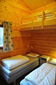 瓦涅Abri Vert的小木屋内一间卧室,配有两张床