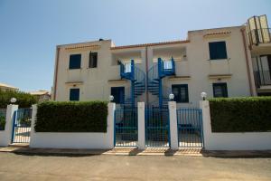 诺托玛丽娜西西里诺托太阳公寓的白色的房子,有蓝色的栅栏和灌木