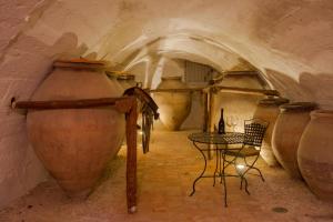 HueteCasa Palacio Conde de Garcinarro的洞穴内带桌子和大花瓶的房间