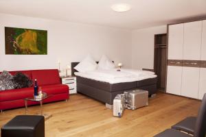 科赫姆联邦银行地堡复古酒店的一间卧室配有一张床和一张红色的沙发