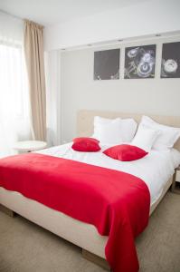 图尔达Potaissa Hotel的一张红色和白色的大床,配有红色枕头
