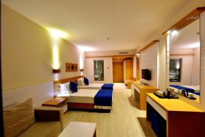 居姆贝特茉莉海滩酒店的酒店客房,设有两张床和一张沙发