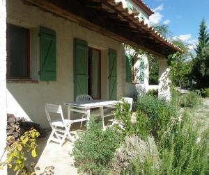 PontevèsVacances en Provence的房屋前设有带2把椅子和1张桌子的庭院。