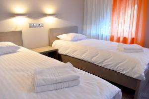 DižstendeKuršu krogs的配有白色床单的酒店客房内的两张床