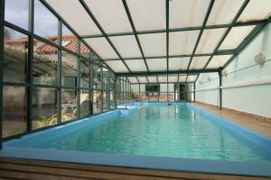 苏克雷Casa Verde B&B的一座带玻璃窗的建筑中的室内游泳池