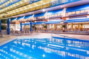 萨洛玛丽娜达酒店的酒店游泳池设有椅子和蓝伞