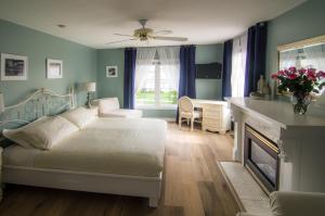 滨湖尼亚加拉优雅酒店的一间卧室配有一张带壁炉和书桌的床。