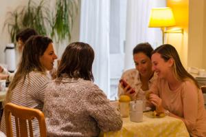 圣达菲Hotel Bertaina的坐在桌子旁说话的一群妇女