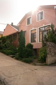 乌日霍罗德Кімнати в центрі的前面有树木的粉红色房子