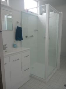 格伦因尼斯昂格里公寓的带淋浴和盥洗盆的白色浴室