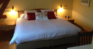 迪尔贝克昂斯姆豪弗旅馆的一间卧室配有一张带两盏灯的大型白色床。