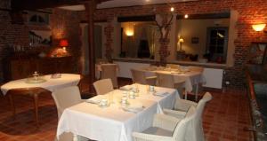 迪尔贝克昂斯姆豪弗旅馆的用餐室配有白色的桌子和白色的椅子