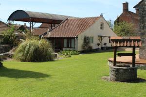 OtheryLittle England Retreats - Cottage, Yurt and Shepherd Huts的院子前有长凳的房子