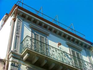 奥托纳Le dimore Al Vecchio Teatro的带阳台的白色建筑,享有蓝色的天空
