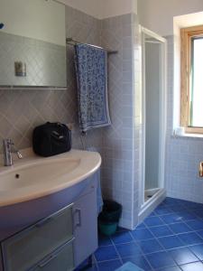 ChiessiCasa Guerrino的蓝色瓷砖浴室设有水槽和淋浴