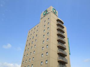 大仙市大曲绿色酒店的一座高大的建筑,上面有标志
