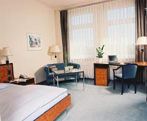 腓特烈斯多夫阿卡迪亚酒店的酒店客房配有一张床和一张带电脑的书桌