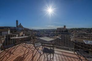 锡耶纳I Terzi Di Siena - Rooms Only的阳台享有城市美景,配有椅子。